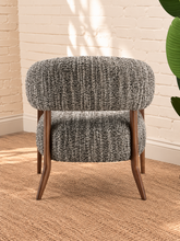 Load image into Gallery viewer, Abby charcoal grey textured bouclé accent chair with curved wraparound backrest, cushioned seat and exposed brown solid wood legs.
