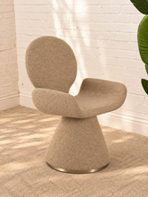 Load image into Gallery viewer, Adler fully upholstered sand dining chair with rounded back, curved wraparound seat, pedestal base, and brushed brass accent.
