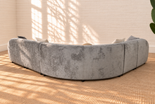 Load image into Gallery viewer, Aela curved sectional sofa upholstered in textured ash grey fabric with rounded corners, square arms, tight back, and five toss pillows.
