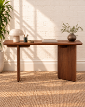 Load image into Gallery viewer, Alijah sculptural desk in natural brown mindi wood with rounded rectangular top, asymmetrical slab legs, and curved under-top supports.
