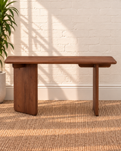 Load image into Gallery viewer, Alijah sculptural desk in natural brown mindi wood with rounded rectangular top, asymmetrical slab legs, and curved under-top supports.
