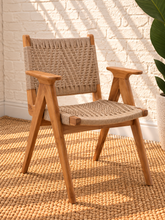 Load image into Gallery viewer, Alma natural teak wood dining armchair with tall synthetic rope woven back, woven seat, and curved wooden armrests.
