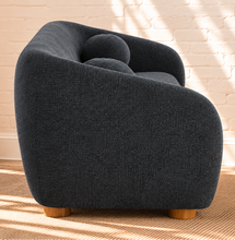 Load image into Gallery viewer, Amara slate navy curved sofa with textured upholstery, rounded arms, ball accent pillows, and wood bun feet
