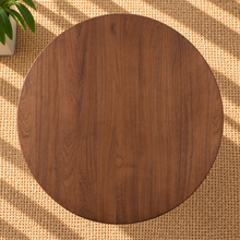 Load image into Gallery viewer, Amari round dining table in natural brown Mindi wood with sculptural rounded column pedestal base and visible wood grain.
