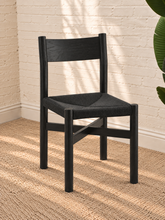 Load image into Gallery viewer, Amelie charcoal solid oak dining chair with woven paper-rope seat, curved wood backrest, rounded legs, and X-shaped stretcher
