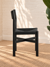 Load image into Gallery viewer, Amelie charcoal solid oak dining chair with woven paper-rope seat, curved wood backrest, rounded legs, and X-shaped stretcher
