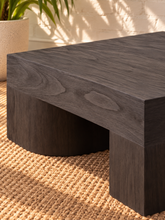 Load image into Gallery viewer, Arnold square coffee table in natural dark brown mindi wood veneer with a thick tabletop and sculptural curved supports.
