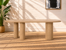 Load image into Gallery viewer, Arya natural ash veneer oval dining table with rounded edges and sculptural triple pedestal legs.
