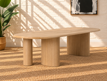 Load image into Gallery viewer, Arya natural ash veneer oval dining table with rounded edges and sculptural triple pedestal legs.
