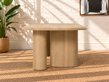 Load image into Gallery viewer, Arya natural ash veneer oval dining table with rounded edges and sculptural triple pedestal legs.
