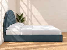 Load image into Gallery viewer, Astrid King-size bed in Slate Blue performance velvet with sculptural arched headboard and streamlined plinth base.

