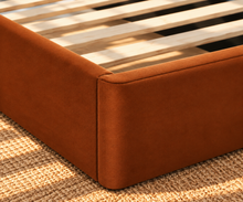 Load image into Gallery viewer, Astrid King-size bed in Terracotta performance velvet with sculptural arched headboard and streamlined plinth base.
