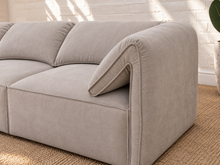 Load image into Gallery viewer, Blaire four piece modular sectional sofa upholstered in cloud gray fabric with four seat cushions, loose back cushions, and softly draped side cushions.
