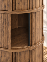 Load image into Gallery viewer, Cairo warm wood cylindrical storage side table with vertical fluted detailing and three sliding tambour doors
