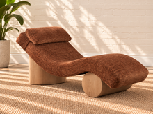 Load image into Gallery viewer, Carlyn sculptural chaise lounge in toasted chestnut polyester with curved upholstery and natural wood base.
