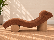 Load image into Gallery viewer, Carlyn sculptural chaise lounge in toasted chestnut polyester with curved upholstery and natural wood base.
