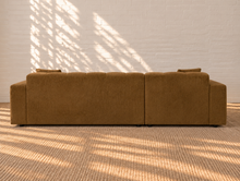 Load image into Gallery viewer, Cayden caramel upholstered L-shaped sectional sofa with left-facing chaise, tufted seat and back, square arms, and two matching throw pillows.
