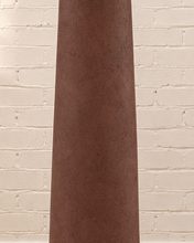 Load image into Gallery viewer, Chandria floor lamp with tall tapered brown fiber cement base, rounded woven rattan shade, and faceted decorative finial.

