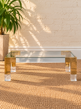 Load image into Gallery viewer, Cindy rectangular coffee table with clear glass top, polished gold stainless steel frame, and transparent acrylic legs.
