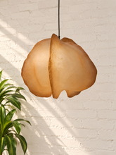 Load image into Gallery viewer, Claire hanging lamp in warm camel resin with an organic sculptural shade, overlapping curved forms, textured surface, and dark cord suspension.
