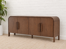 Load image into Gallery viewer, Collin four-door dark walnut media cabinet with rounded upper corners, integrated wood pulls and slim solid wood legs.
