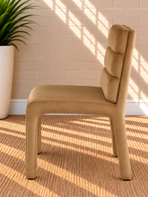 Load image into Gallery viewer, Conrad upholstered dining chair in Honey Cognac velvet with deep channel-tufted back and sculptural frame
