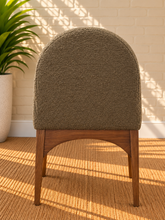 Load image into Gallery viewer, Davila Walnut dining armchair upholstered in Weathered Olive bouclé with curved arms and sculptural wood frame
