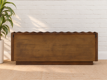 Load image into Gallery viewer, Eden natural brown mango wood credenza with sculptural wave-edged detailing, paneled cabinet doors, concealed shelving, and recessed plinth base.

