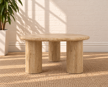 Load image into Gallery viewer, Eisley beige travertine freeform coffee table with three cylindrical pedestal legs and natural stone variation.
