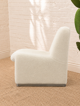 Load image into Gallery viewer, Etta white upholstered accent chair with rounded back, curved seat, sculptural side panels and silver-tone feet.
