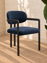 Load image into Gallery viewer, Ezra midnight blue textured upholstered dining armchair with rounded back, open silhouette, and black metal frame
