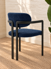 Load image into Gallery viewer, Ezra midnight blue textured upholstered dining armchair with rounded back, open silhouette, and black metal frame

