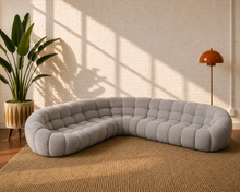 Load image into Gallery viewer, Large grey curved modular sectional sofa with deep channel tufting, rounded arms and sculptural low-profile design.
