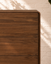 Load image into Gallery viewer, Finley five-drawer dresser in warm walnut with natural wood grain, rounded corners and handle-free push-to-open drawer fronts.
