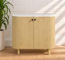 Load image into Gallery viewer, Frida sand mango wood bar cabinet with curved fluted doors, black knobs, rounded legs, and white marble top
