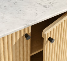 Load image into Gallery viewer, Frida sand mango wood bar cabinet with curved fluted doors, black knobs, rounded legs, and white marble top

