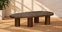Load image into Gallery viewer, Henry solid oak coffee table in Natural Brown with organic rounded tabletop, four cylindrical legs, and prominent natural wood grain.
