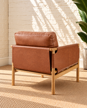 Load image into Gallery viewer, Hilario lounge chair in toasted cognac faux leather with solid ash wood frame and rounded wooden arms
