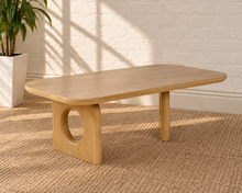 Load image into Gallery viewer, Kamari natural oak rectangular coffee table with rounded corners and two sculptural panel legs featuring circular cutouts.
