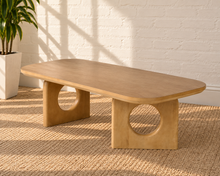 Load image into Gallery viewer, Kamari natural oak rectangular coffee table with rounded corners and two sculptural panel legs featuring circular cutouts.
