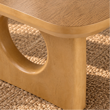 Load image into Gallery viewer, Kamari natural oak rectangular coffee table with rounded corners and two sculptural panel legs featuring circular cutouts.
