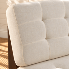 Load image into Gallery viewer, Karyl Ivory armless accent chair with ivory tufted upholstery, removable cushions and sculptural walnut-finished oak wood frame.
