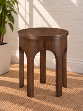 Load image into Gallery viewer, Kaylee sculptural side table in natural brown with a round top and arched Art Deco-inspired base.
