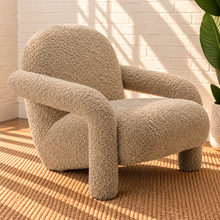 Load image into Gallery viewer, Kinsley latte beige textured upholstered accent chair with rounded back, cushioned seat and sculptural arms and legs.
