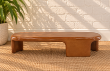 Load image into Gallery viewer, Klarisse caramel high-gloss concrete coffee table with elongated rounded top and sculptural waterfall-style supports.
