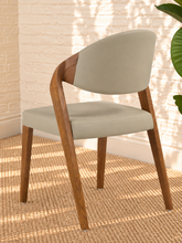 Load image into Gallery viewer, Kori warm greige leatherette dining chair with curved upholstered back and walnut-finished solid ash wood frame.
