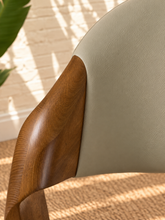 Load image into Gallery viewer, Kori warm greige leatherette dining chair with curved upholstered back and walnut-finished solid ash wood frame.
