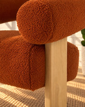 Load image into Gallery viewer, Kourtney burnt orange textured accent chair with curved flared arms, cushioned seat and natural wood legs.
