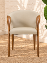 Load image into Gallery viewer, Kyra greige vegan leather dining armchair with curved back, sculpted solid ash wood arms and legs, and cushioned seat.
