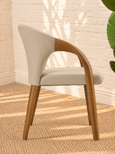 Load image into Gallery viewer, Kyra greige vegan leather dining armchair with curved back, sculpted solid ash wood arms and legs, and cushioned seat.
